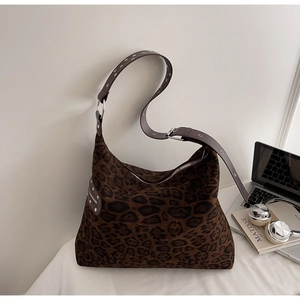 Detail of leopard print hobo bag showing adjustable metal eyelet strap and soft fabric texture