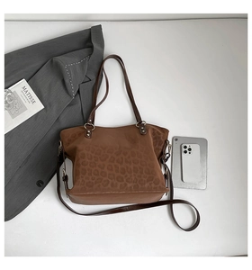 Detail of large brown leopard print tote bag with shoulder straps and autumn style props