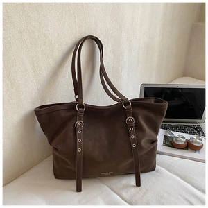 Detail view of the dark brown matte leather tote bag with stylish metal buckle straps