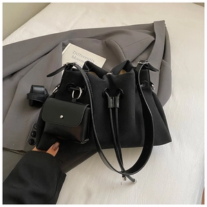 Detail of black canvas bucket bag with drawstring closure and leather sub-pouch