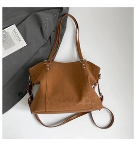 Detail of deep brown faux leather tote bag featuring subtle leopard print texture