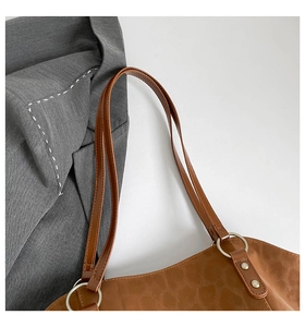 Close-up of leopard print tote bag with silver metal ring and fine rivet hardware detail