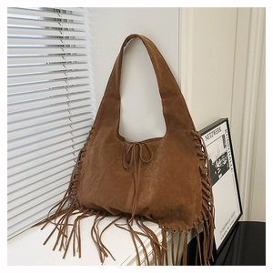 Detail view of brown suede fringe tote bag showing weaving craft and tassel accents