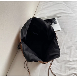Vue détaillée de l'intérieur d'un grand sac cabas marron avec poche et ordinateur