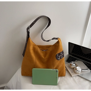 Detail view of large leopard suede tote bag with brown leather strap and metal eyelets