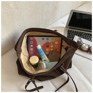 Top view of spacious interior in coffee suede tote bag with tablet and daily essentials
