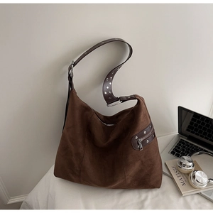 Detail showing deep brown suede tote bag texture with silver grommet shoulder strap
