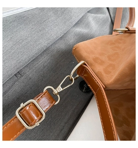 Detailed close-up of brown leopard print faux suede tote with silver metal hardware