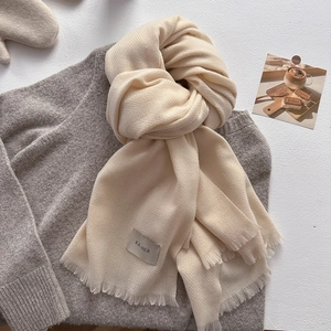Detail of cream pashmina scarf with herringbone weave texture and tassel fringes