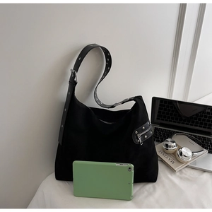 Detail of black large hobo bag featuring silver eyelets and side zipper pocket