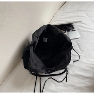Vue de dessus de l'intérieur spacieux d'un grand sac cabas noir souple avec détails de ruban