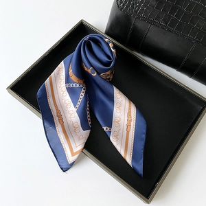 Detail of navy silk scarf with gold chain print and scroll patterns on display