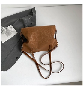Macro shot of brown leopard print bag with silver rings and stylish shoulder straps