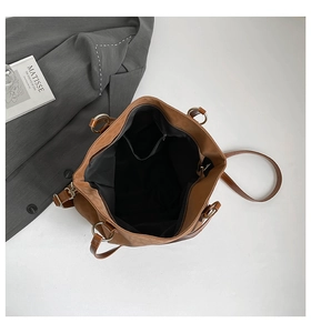 Detailed view of large brown tote bag interior featuring zipper pocket and black lining