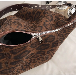 Detailed macro view of the leopard print suede fabric and silver metal zipper closure