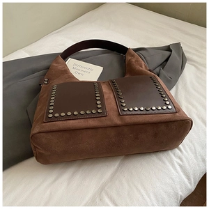 Nahaufnahme braune Wildleder-Schultertasche mit Vintage-Nieten und Ledertaschen