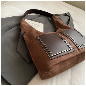 Detailansicht der braunen Wildledertasche mit Vintage-Nieten und dunklen Leder-Patches