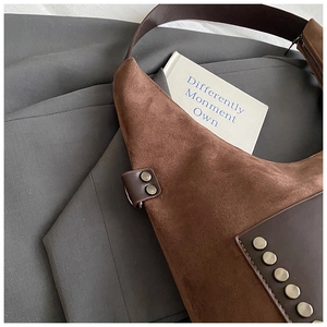 Details einer Vintage Wildledertasche in Braun mit Nieten und geräumigem Innenraum