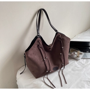 Détails d'un sac porté épaule en daim avec franges à perles argentées et lanière