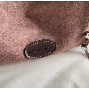 Vue macro détaillée de la texture daim doux et du logo en cuir du sac fourre-tout