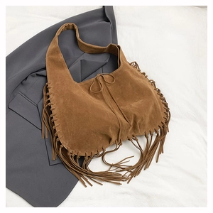 Detail of brown suede hobo bag featuring long tassels and a minimalist drawstring closure
