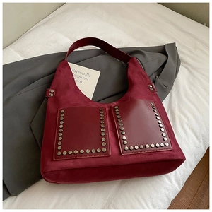 Detailansicht der burgunderroten Wildledertasche mit Nieten und Ledertaschen