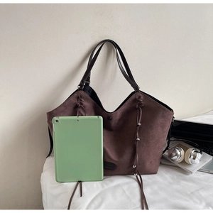 Détail du grand sac cabas en daim marron avec des franges et un intérieur spacieux