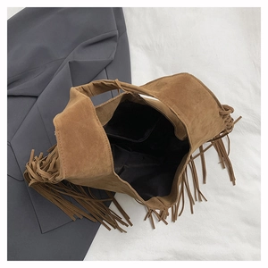 Detail shot of brown suede tote bag with fringe tassels and internal zipper pocket