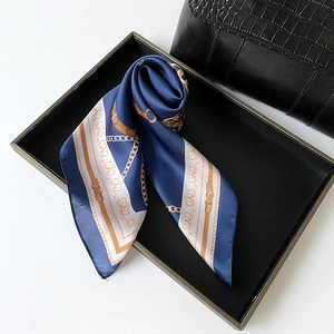 Elegant navy satin silk square scarf with golden chain print on a black display tray