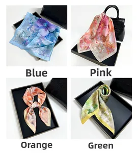 Floral print satin silk scarves in blue, pink, orange, and green on a display tray