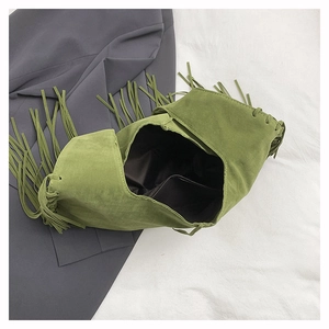 Detail of green suede tote bag showing fringe accents and spacious interior lining