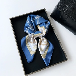 Détail d'un foulard en satin avec des motifs de chaînes dorées et de roses sur soie