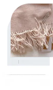 Gros plan sur la texture du foulard rose clair doux avec détails de franges