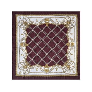 Détails d'un foulard en soie rouge et blanc avec chaînes dorées baroques et motifs floraux