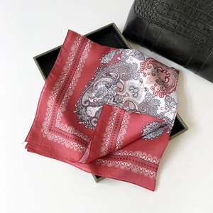 Close-up of deep red Paisley silk scarf with satin texture and elegant pattern details