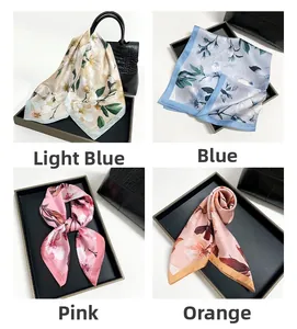 Detail of floral magnolia print satin scarves in light blue, blue, pink, and orange