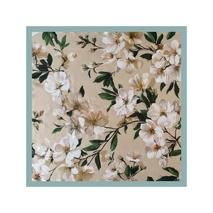 Detailed top-down view of square satin scarf with magnolia flowers and blue-grey border
