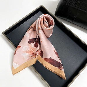 Detail of pink floral satin scarf with magnolia pattern and champagne gold edges