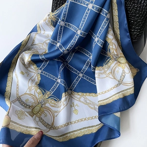 Carré de soie bleu marine élégant avec chaînes dorées et motifs floraux sur cuir noir