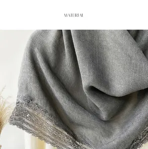 Detail view of dark grey cotton linen scarf fabric with delicate black lace trim