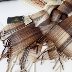 Detalle de la bufanda de 100% lana australiana con un patrón de cuadros beige y flecos