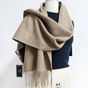 Macro detail of camel Australian sheep wool scarf featuring soft texture and fine tassels