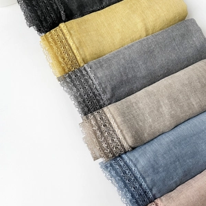 Close-up of cotton linen scarves featuring delicate lace edges in various colors