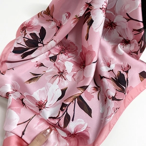 Elegant satin scarf with realistic white magnolia flower prints on a soft pink background