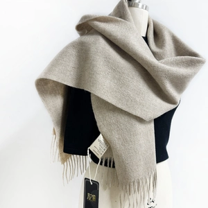 Detail of premium beige Australian wool scarf featuring elegant fringe and soft brushed texture
