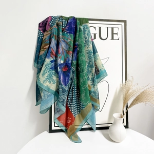 Dettaglio di un grande foulard di seta con vivaci motivi floreali blu e verde stampati