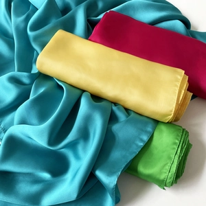 Detalle de pañuelos de seda satinada de colores con costuras finas y textura brillante