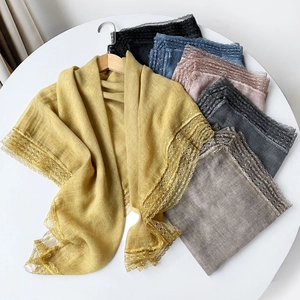 Detail of lightweight cotton linen scarves featuring delicate wide lace trim in various colors
