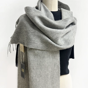 Close-up of dark grey Australian wool scarf with fringe detail on a simple black garment