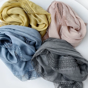 Detail of four colorful linen scarves with delicate eyelash lace edges on white background